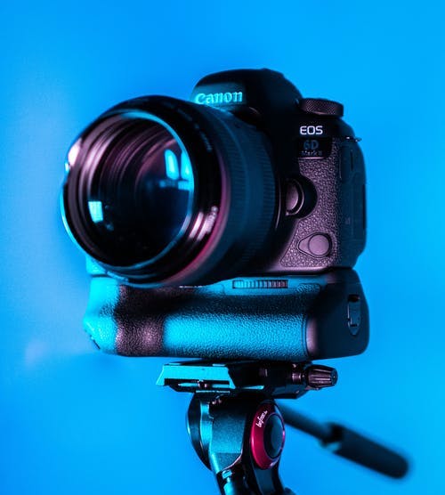 Camera on tripod in front of blue background - look good on camera