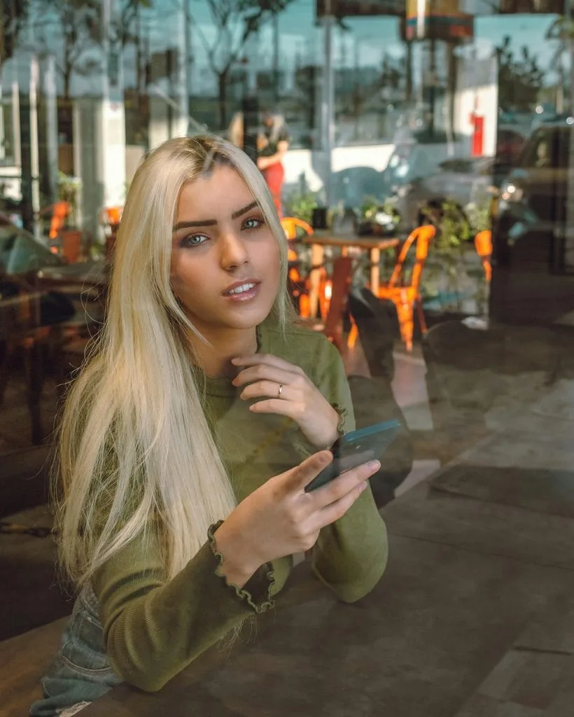 An image of a UK cam girl using social media on her phone.